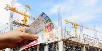 Parque industrial en México con plantas manufactureras en operación y grúas de construcción al fondo