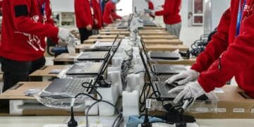 Trabajadores en planta de manufactura electrónica en México con equipo de componentes y circuitos