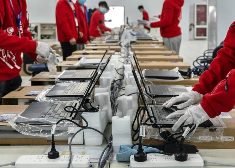 Trabajadores en planta de manufactura electrónica en México con equipo de componentes y circuitos