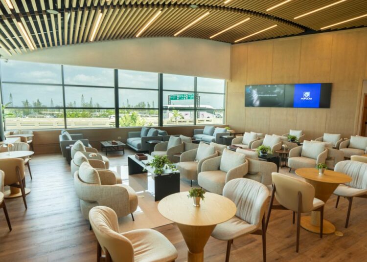 Interior del Lounge Popular en el Aeropuerto Internacional de Las Américas, con área de descanso y servicio de alimentos para tarjetahabientes
