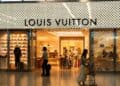 Fachada de tienda LVMH en avenida comercial de lujo con pasantes frente a escaparate
