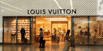 Fachada de tienda LVMH en avenida comercial de lujo con pasantes frente a escaparate