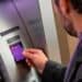 Tarjeta Nu morada sobre pantalla de cajero automático mostrando comisión de retiro de efectivo