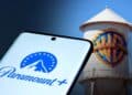 Logos de Paramount y Warner Bros. Discovery en pantallas frente a edificios corporativos en Estados Unidos