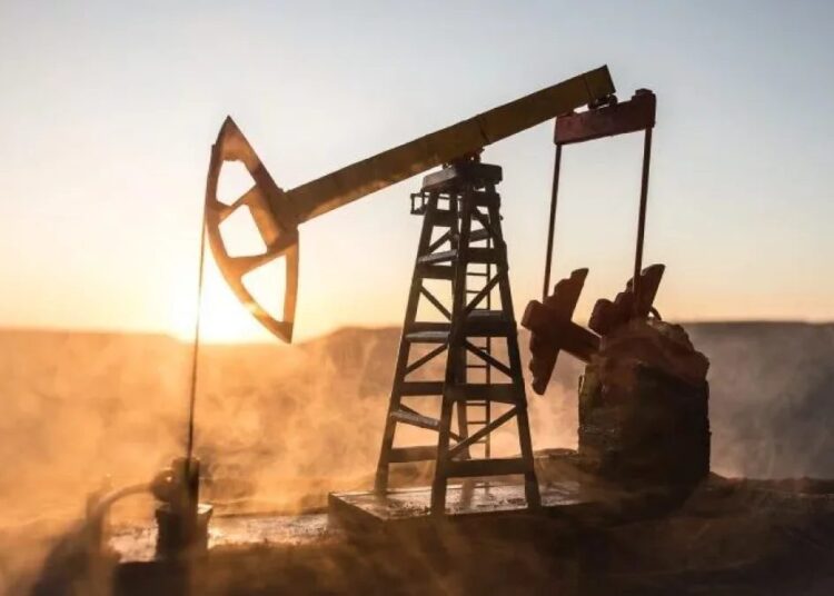 Refinería de petróleo con flamas encendidas y torres de extracción al atardecer en Oriente Medio