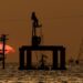 Instalaciones petroleras en Venezuela con trabajadores y equipos de extracción de crudo al atardecer