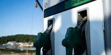 Refinería de petróleo con tanques de almacenamiento de diésel y chimeneas activas al atardecer