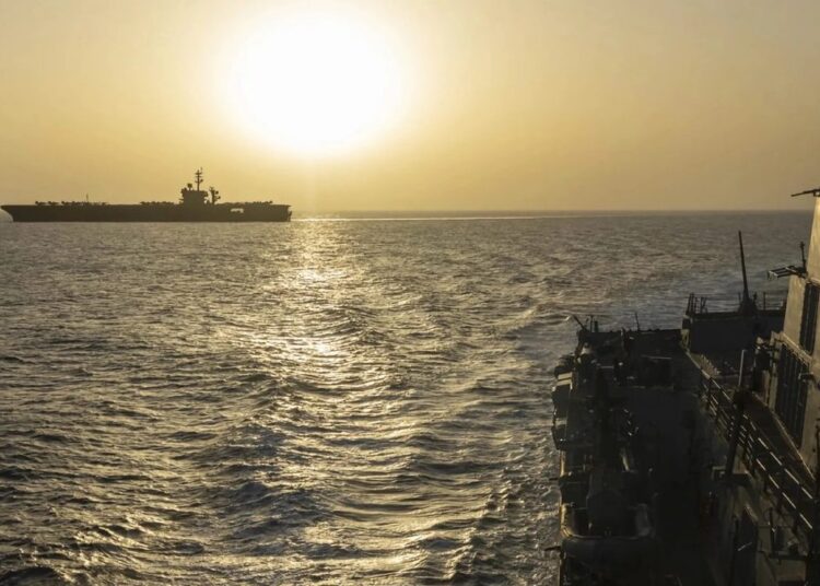Buque tanque petrolero navegando por el estrecho de Ormuz con instalaciones de extracción de petróleo al fondo