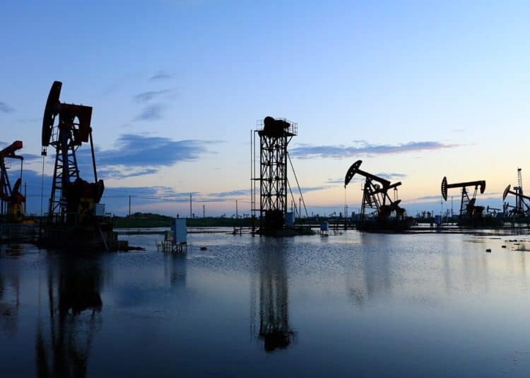 Plataforma de extracción de petróleo WTI en Texas con fondo de cielo nublado y humo industrial