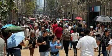 Trabajadores en una oficina formal en México revisando recibos de nómina