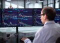Pantalla del Nasdaq mostrando caídas en Wall Street mientras el precio del petróleo sube por tensión en Medio Oriente