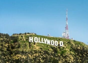 Claqueta de cine sobre una mesa de reuniones con documentos financieros y gráficos de inversión