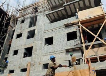Obras de construcción de viviendas en República Dominicana con materiales apilados en primer plano