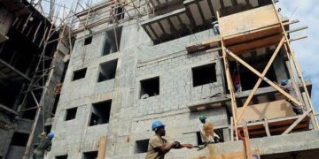 Obras de construcción de viviendas en República Dominicana con materiales apilados en primer plano