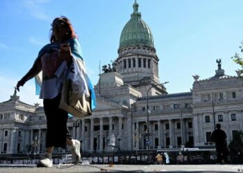 Trabajadores estatales argentinos frente a edificio del gobierno en Buenos Aires durante protesta contra recortes de empleo público