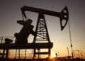 Refinería de petróleo con torres de destilación encendidas mientras los futuros del WTI caen tras noticias diplomáticas en Teherán