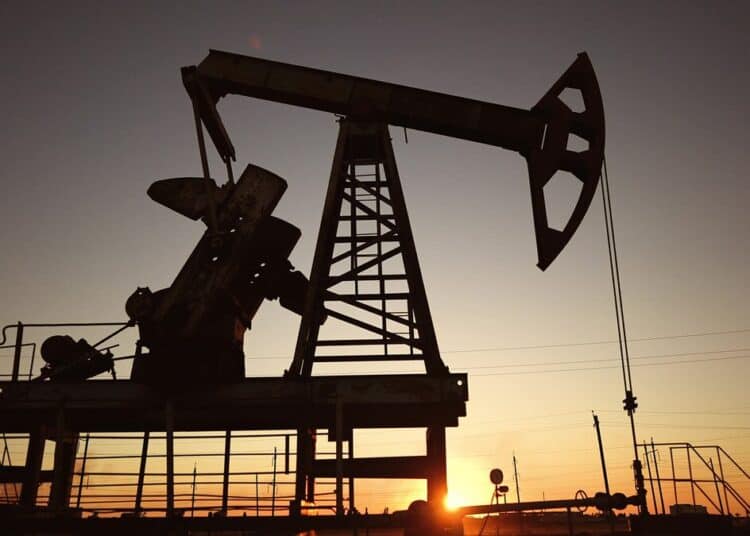 Refinería de petróleo con torres de destilación encendidas mientras los futuros del WTI caen tras noticias diplomáticas en Teherán