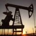 Refinería de petróleo con torres de destilación encendidas mientras los futuros del WTI caen tras noticias diplomáticas en Teherán