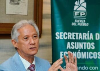 Conductor colocando el marbete en el parabrisas de su vehículo en Santo Domingo en 2026
