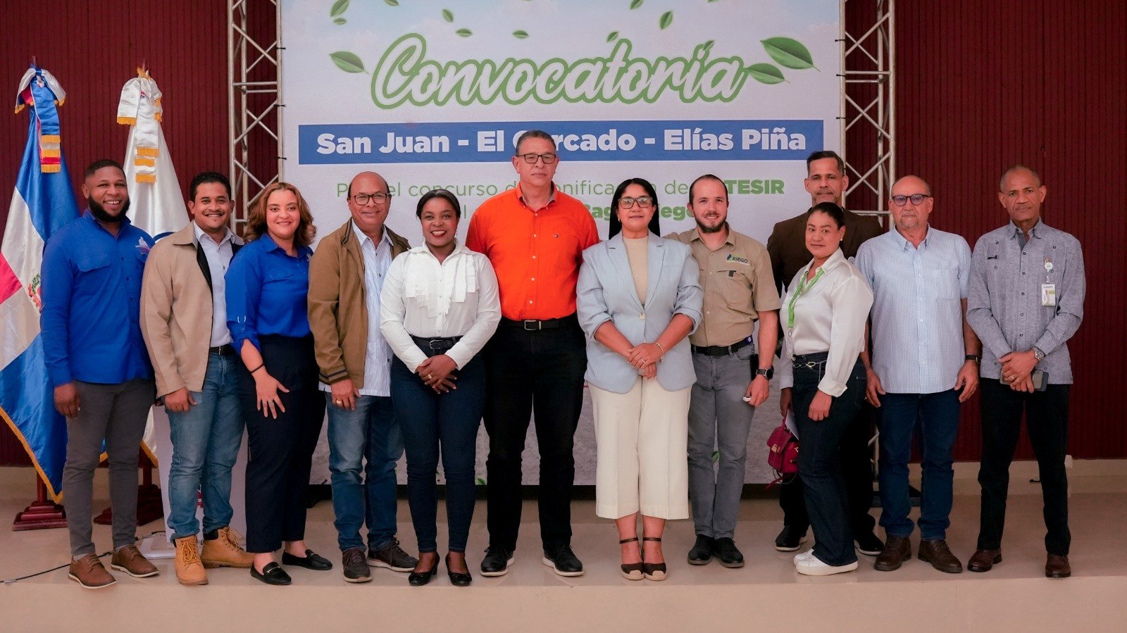 Grupo de funcionarios posa ante un cartel de convocatoria sobre tecnificación del riego en San Juan, El Cercado y Elías Piña.