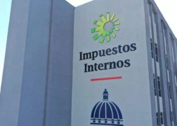 Funcionaria de la DGII revisando documentos de facturación electrónica en oficina tributaria de Santo Domingo
