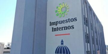 Funcionaria de la DGII revisando documentos de facturación electrónica en oficina tributaria de Santo Domingo