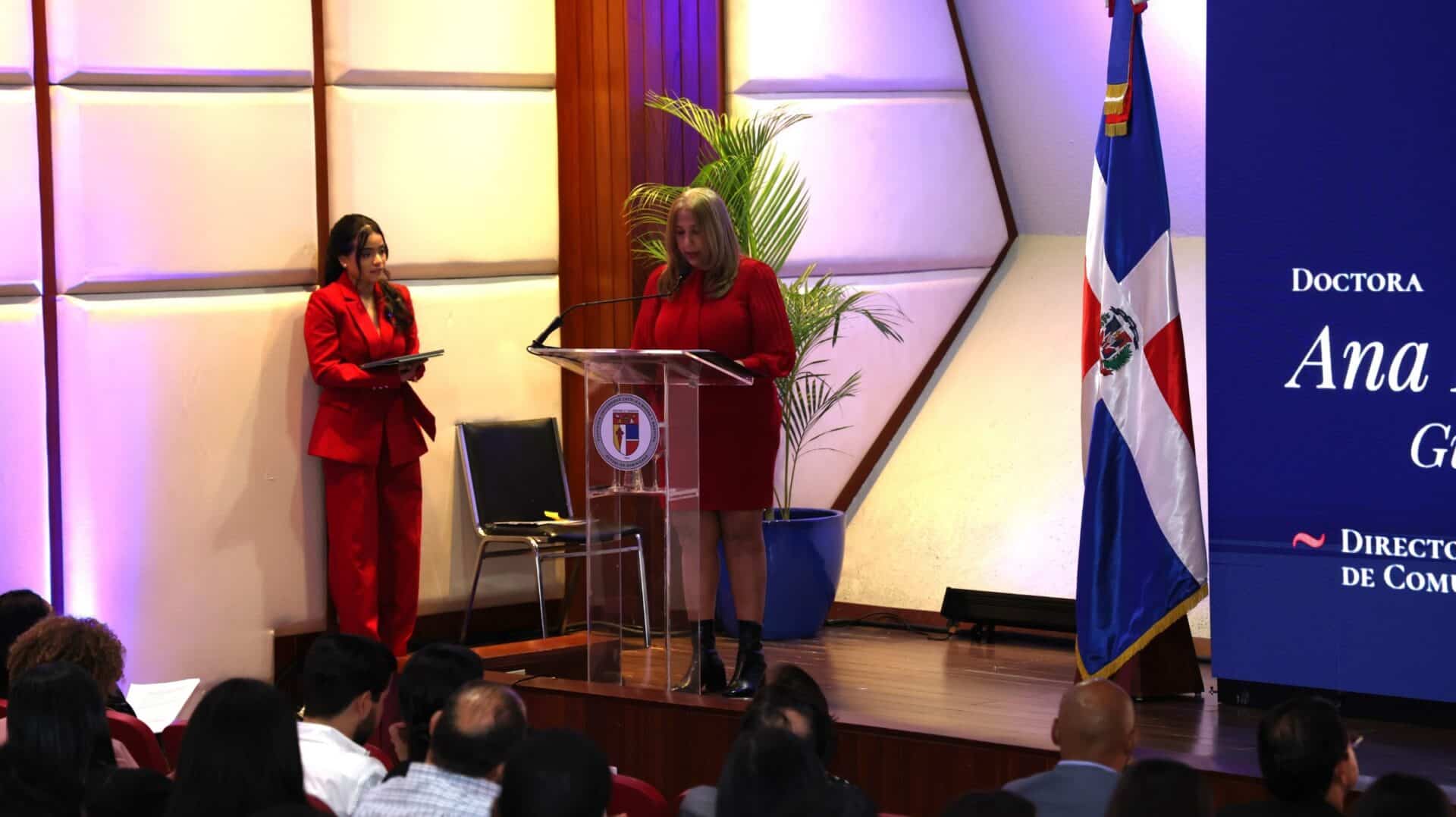 La doctora Ana G. habla en un podio durante la jornada de comunicación corporativa de la PUCMM en Santo Domingo.