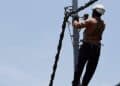 Brigadas técnicas de la ETED trabajando en torres de transmisión eléctrica de 69 kV en República Dominicana