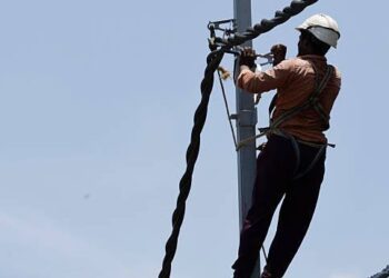 Brigadas técnicas de la ETED trabajando en torres de transmisión eléctrica de 69 kV en República Dominicana