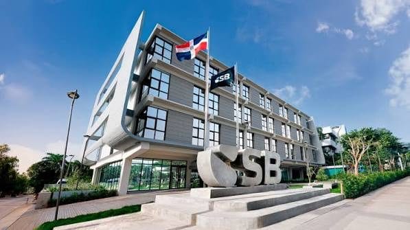 Sede de la Superintendencia de Bancos de República Dominicana y pantalla con el sitio web de SoluDinero.com