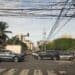 Postes con múltiples cables aéreos de electricidad y telecomunicaciones sobre una calle de Santo Domingo