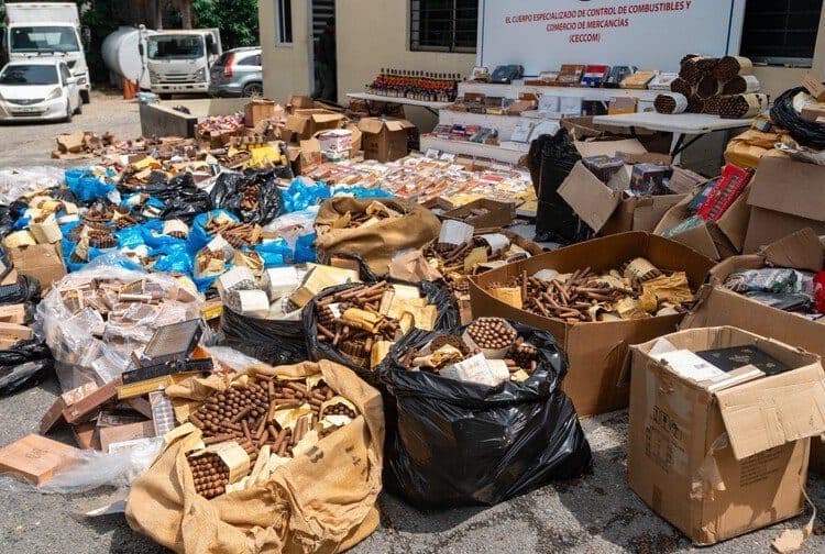 Agentes del Ceccom junto a cajas de cigarros premium y botellas de mamajuana incautadas en Higüey, provincia La Altagracia