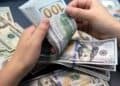 Manos contando billetes de cien dólares estadounidenses