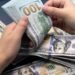 Manos contando billetes de cien dólares estadounidenses