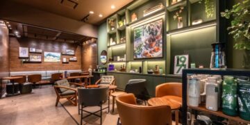 Fachada de una cafetería Starbucks con letreros de cierre temporal durante reestructuración corporativa